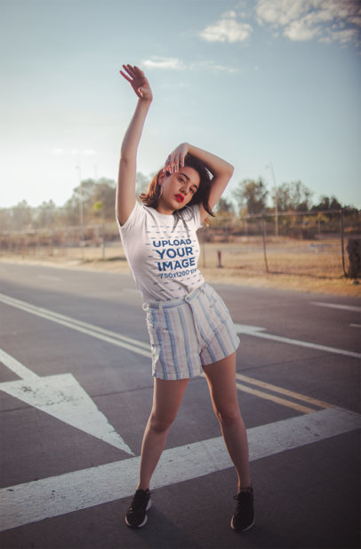 T-Shirt Mockup Featuring an Appealing Woman Posing on a Road