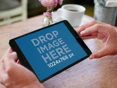 Mockup of a Black iPad Mini Held in a Coffee Restaurant