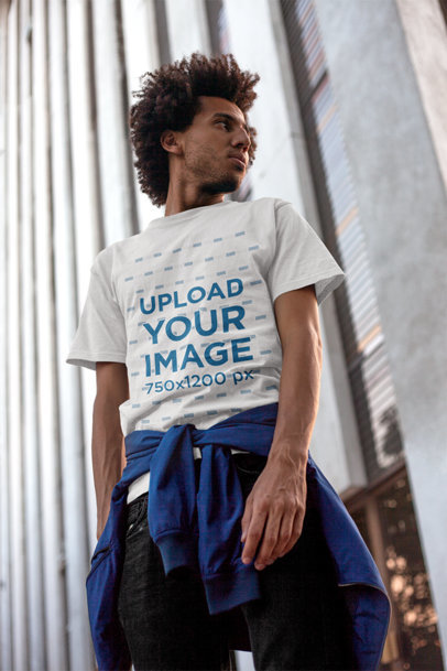 T-Shirt Mockup of a Man Standing by a City Building