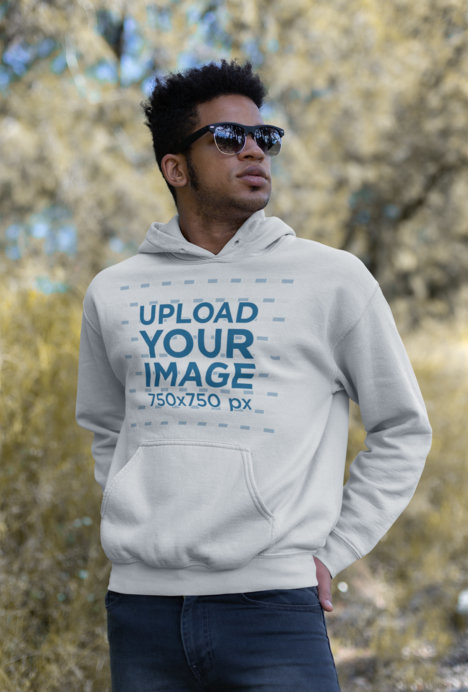 Mockup Featuring a Cool Man Wearing a Pullover Hoodie and Sunglasses Outdoors