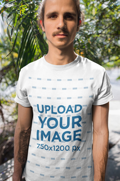 T-Shirt Mockup Featuring a Man with a Hipster Mustache in Front of Plants