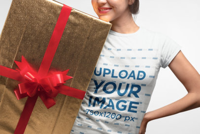 Christmas Tee Mockup Featuring a Woman Holding a Large Gift