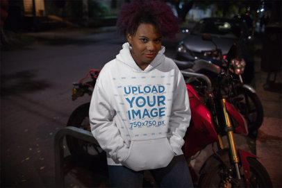 Hoodie Mockup of a Woman with an Afro Standing by Motorbikes
