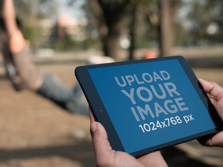Mockup of a Man Using an iPad at a Park 