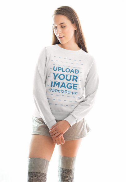 Mockup of a Woman Wearing a Crewneck Sweater Against a Bright Light