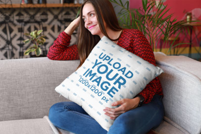 Mockup of a Happy Woman Holding a Pillow Sitting on a Sofa