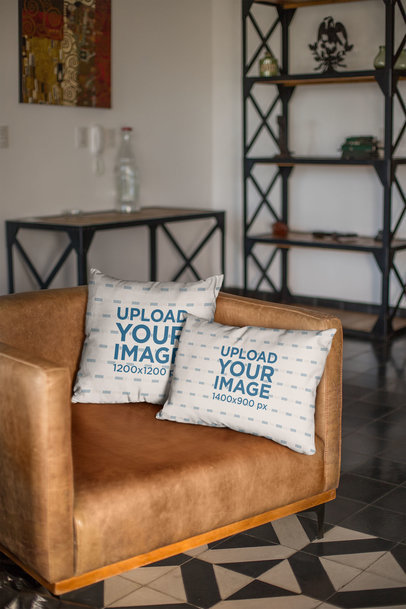 Mockup of Two Throw Pillows on a Leather Couch