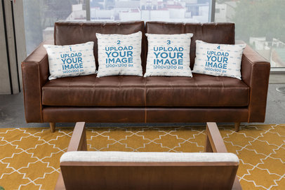 Mockup of Four Pillows on a Leather Sofa