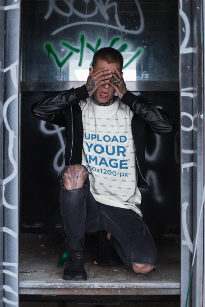 Mockup of a Tattooed Man at an Urban Location Wearing a Baggy Tee