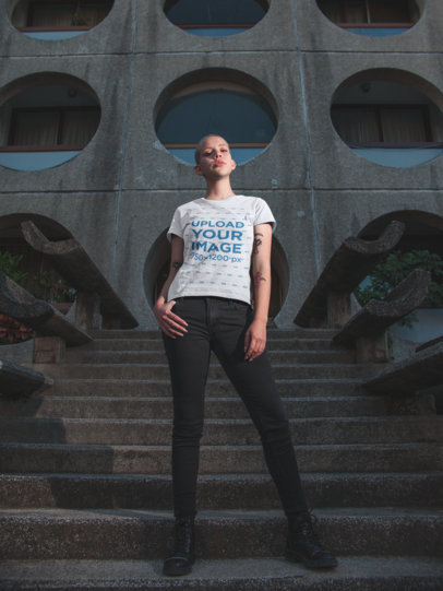 T-Shirt Mockup of a Beautiful Woman with a Buzz Cut Haircut in Front of a Building