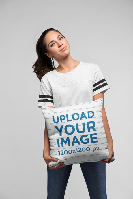 Mockup of a Woman Holding a Pillow Against a Flat Background