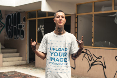 Tee Mockup of a Tattooed Punk Man in Front of an Abandoned Building 