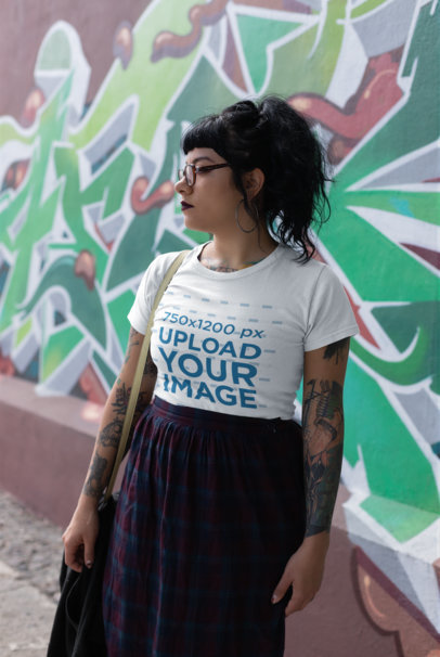 T-Shirt Mockup of a Tattooed Woman Near a Graffiti Wall