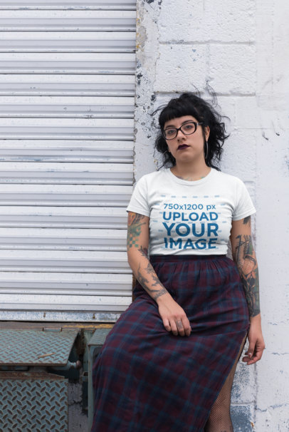 Tee Mockup Featuring a Cool Goth Woman Leaning on a White Wall