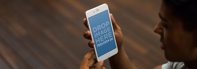 iPhone 6 Mockup Template of a Man Holding an iPhone at Home