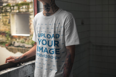 T-Shirt Mockup Featuring a Tattooed Man with Cropped Face