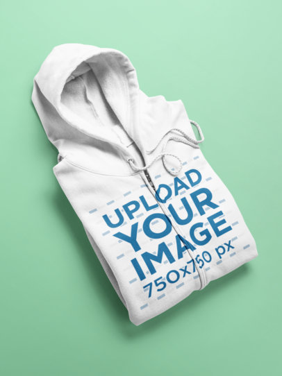 Flat Lay Mockup of an Angled Full Zip Hoodie Over a Surface