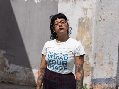 Mockup of a Tattooed Girl Wearing a Tshirt Against an Old Wall 23445