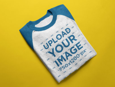 Mockup of a Raglan T-Shirt Lying Folded on a Solid Surface