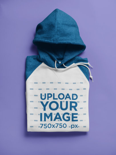 Folded Raglan Pullover Hoodie Mockup on a Flat Surface