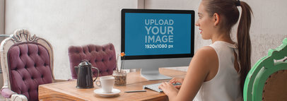 iMac Mockup of a Young Woman Working on an iMac at a Creative Office 