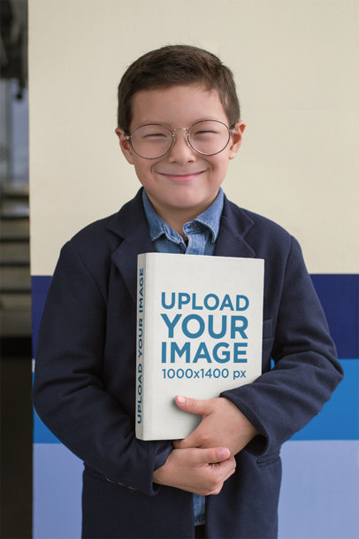 Back to School Mockup of a Young Smiling Boy Holding A Book to His Chest