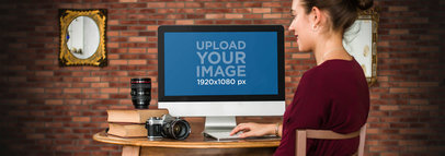Mockup of a Young Female Photographer Working on an iMac 