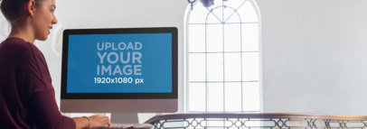 Mockup of a Young Woman Working on an iMac at a Design Office