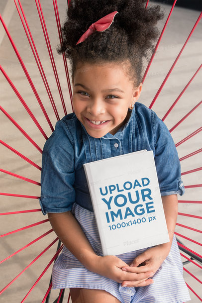 Book Mockup Featuring a Small Girl Sitting on an Acapulco Chair 23718