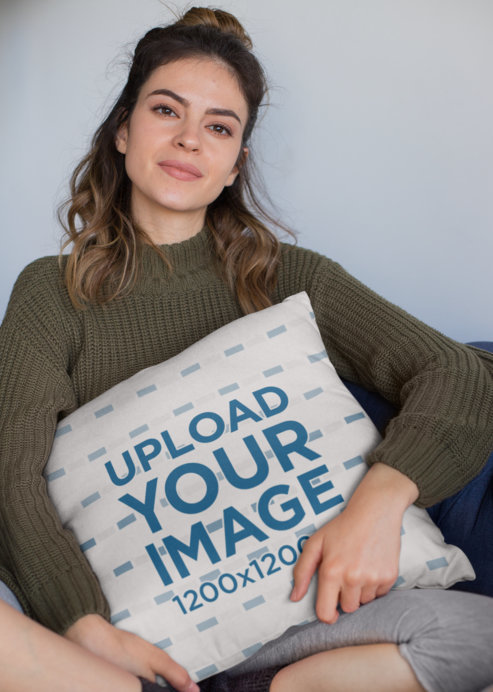 Mockup of a Woman Holding a Square Pillow While Sitting