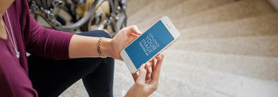 Young Woman Sitting on a Staircase Using an iPhone 7 Mockup