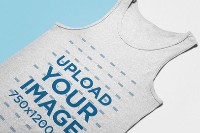 Angled View Mockup of a Heather Tank Top Lying on a Flat Surface