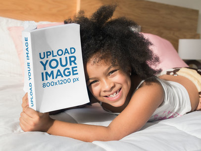 Mockup of a Smiling Girl Reading a Book on her Bed