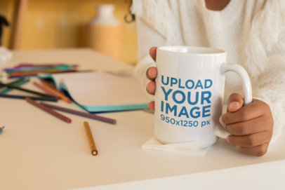 Mockup of a Mug Held by a Child Surrounded by Colored Pencils 24007