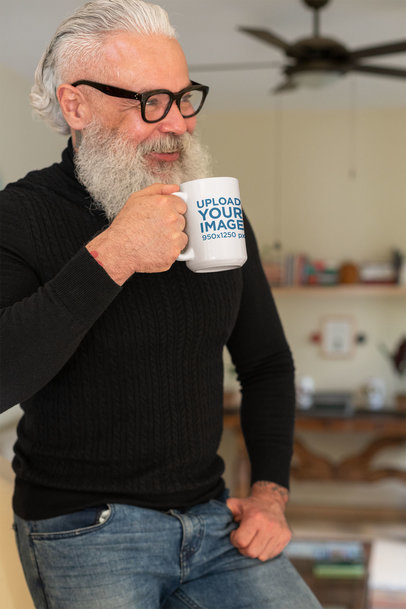 Mockup of a Hipster Man Holding a 15 oz Coffee Mug at his House