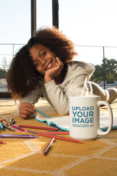 Coffee Mug Mockup of a Happy Girl Drawing While Lying on the Floor 24010