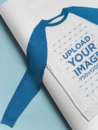 Mockup of a Raglan Long Sleeve Tee Lying Over a Bent Pasteboard 24361
