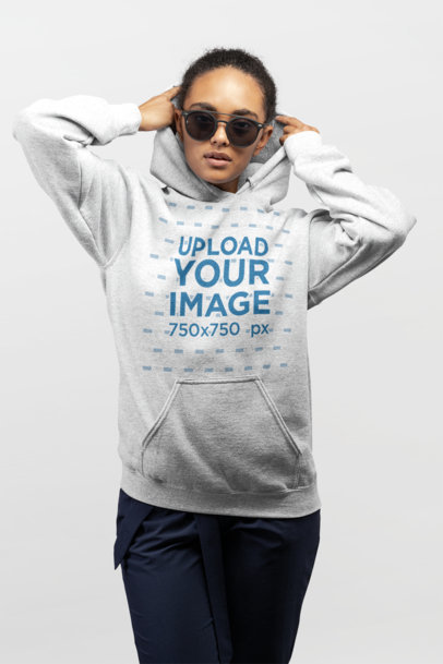 Mockup of a Woman Adjusting Her Hoodie While Wearing Trendy Sunglasses