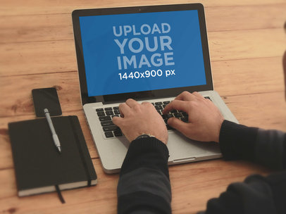 MacBook Mockup Featuring a Man Working on a Table
