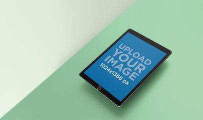 Mockup of an iPad Floating Over a Solid Color Surface