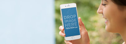 Young Lady Walking Around Town Using iPhone 6 Mockup