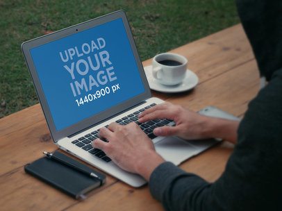 Mockup of a Man Working Outdoors on a MacBook
