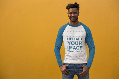 Mockup of a Trendy Man Wearing a Raglan Tee in Front of a Bright Wall 24113