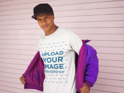 T-Shirt Mockup of a Cool Man Smiling in Front of a Wall
