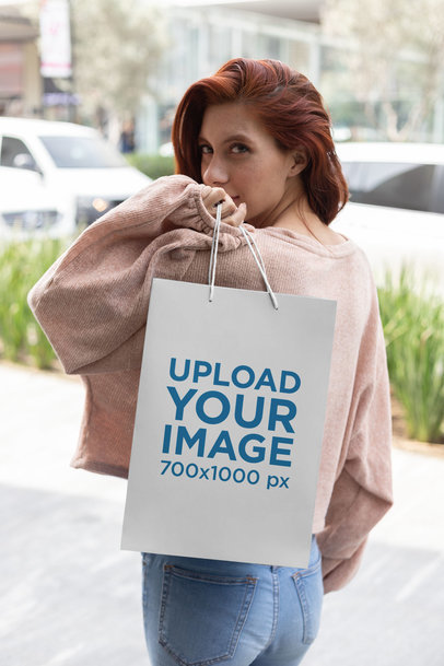 Gift Bag Mockup of a Woman Showing off a Gift Bag over Her Shoulder