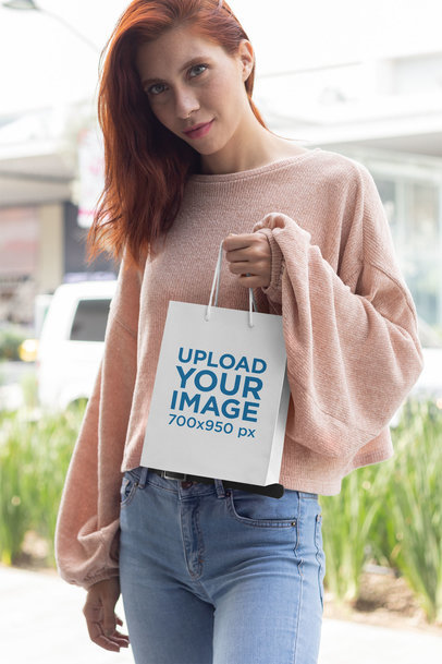 Mockup of a Woman Holding Up a Gift Bag