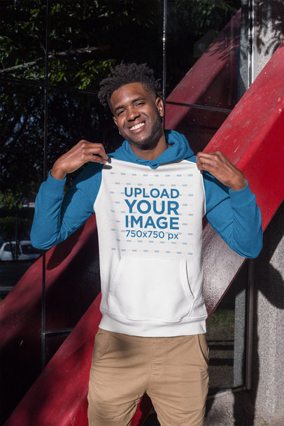 Mockup of a Happy Man Showing off his Raglan Hoodie