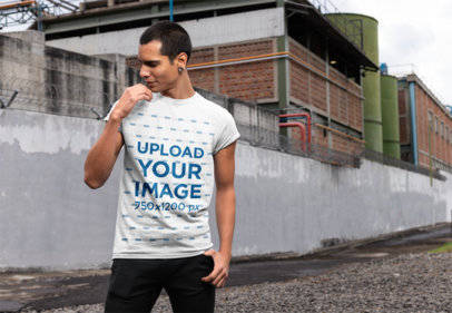 Mockup of a Man Wearing a T-Shirt in an Industrial Area