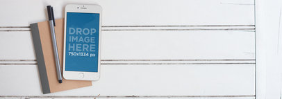 Mockup Featuring a White iPhone 6 Lying on Top of a Notebook 
