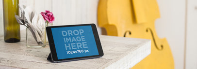 iPad Sitting on Top of a Dinner Table Next to a Yellow Cello Mockup a5504